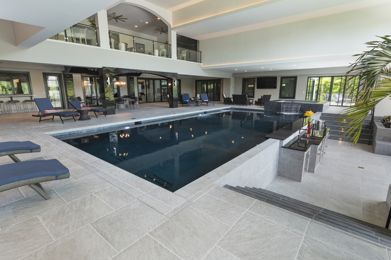 Indoor rectangular pool installed with a water feature in one corner.